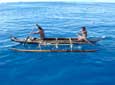 Two fishermen in an outrigger canoe offshore Anuta